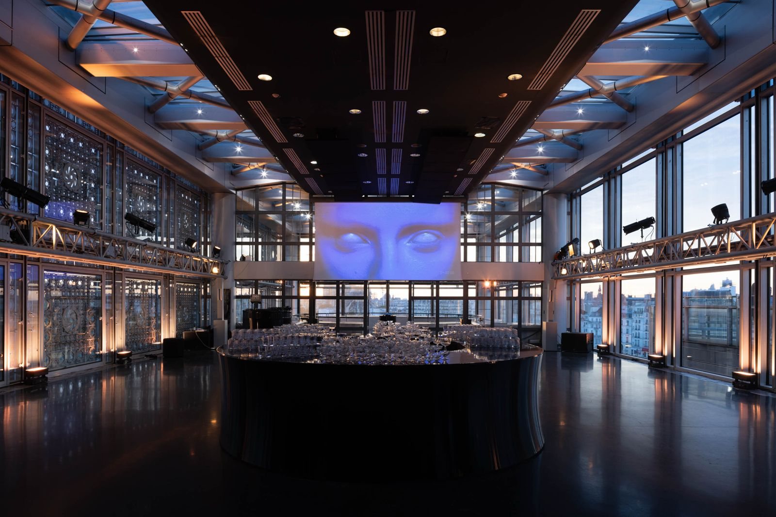 Event set-up in a glass rooftop venue at dusk